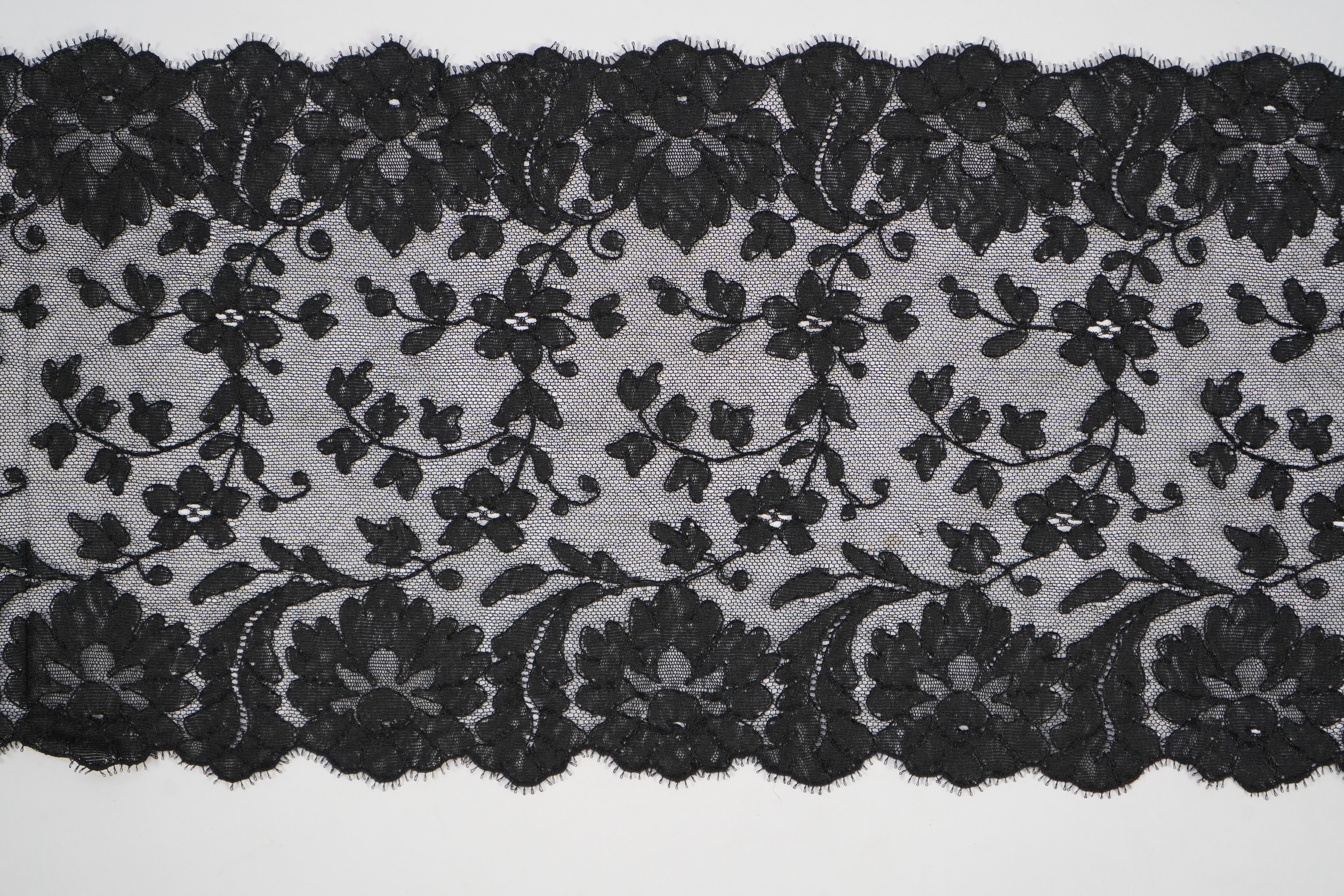 A collection of mixed machine lace: a black lace stole, two black veils, a sample of Japanese brocade, a length of metallic ribboning and various items of cream lace, ribboning 230cm long. Condition - variable poor to fa